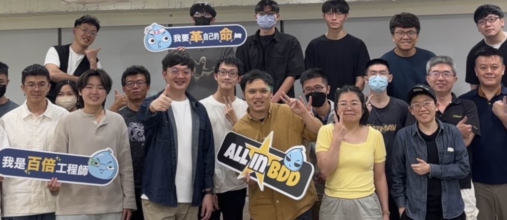 學員合照,手上舉著「我是百倍工程師」「我要革自己的命」「ALL IN BDD」